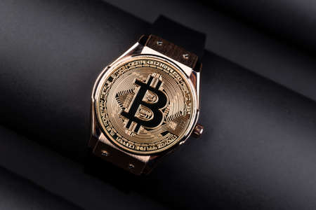 Bitcoin time concept on creative background.. Golden Bitcoin over the watch . Time cryptocurrency...