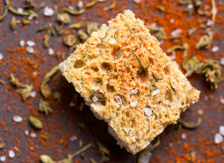 Crispy crouton with spices over wood table. Close up of piece of Crispy crouton with spices