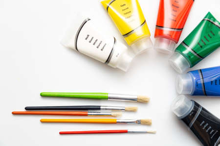 Brushes with acrylic color tubes. Colorful acrylic paints over white backgroundの写真素材