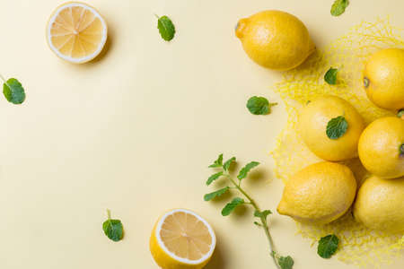 Top view of lemons and mint over yellow backgroundの写真素材