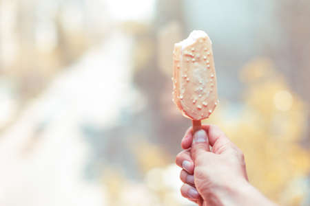 Person holding a ice cream covered with chocolateの写真素材