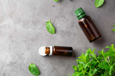 Bottles with aromatherapy oil and mint leaf. Essential oil from mint leaf. Place for textの写真素材