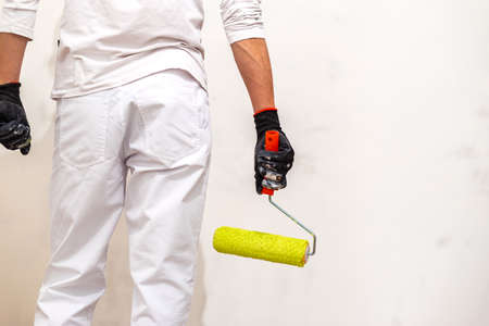 Painter use paint roller on white wall