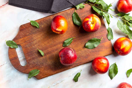 Fresh Nectarines over wood chipper on marble tableの写真素材