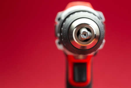 Macro shot of chuck drill Battery screwdriver or drill over red background