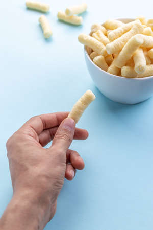 Person who taste crunchy corn puffs, pufuletiiの写真素材