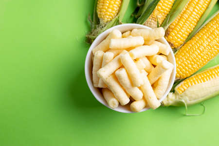Pufuleti and Fresh Grains of ripe corn,  over green backgroundの写真素材
