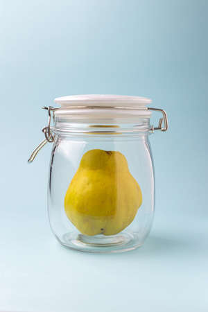 Quince ripe in the jar for conservation over blue backgroundの写真素材
