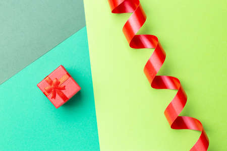Top view of minimalist greeting card with red gift box over pastel background with place for textの写真素材