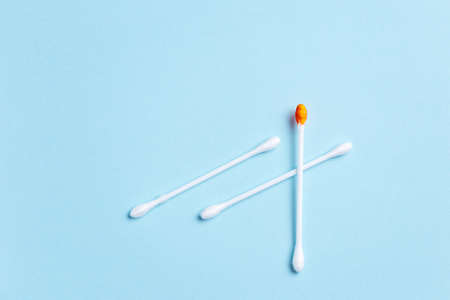 Hygiene cotton stick with blood over blue background with place for textの写真素材