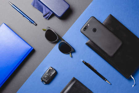Set of men accessories, sunglasses, agenda, car key, pen , smartphone over two colors creative...