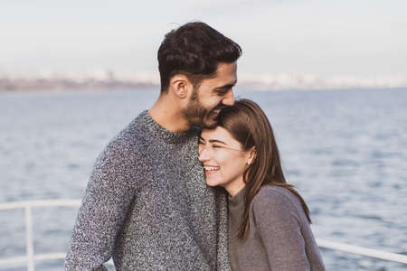 Young couple have good time on cruise ship. Portrait of beautiful young couple laughingの写真素材