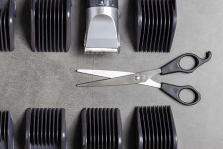 Scissors with hair clipper and accessories over black background