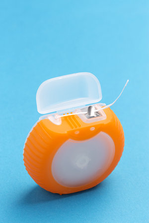 Orange dental floss box on blue backgroundの写真素材