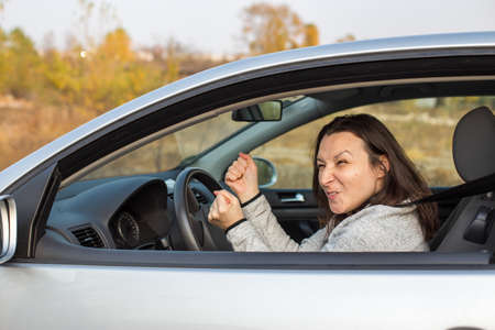 Temperamental driver concept, angry woman in trafficの写真素材