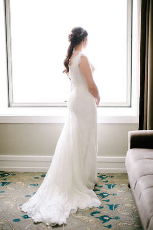 The bride poses facing back. He looks out the window. Indoor.の写真素材