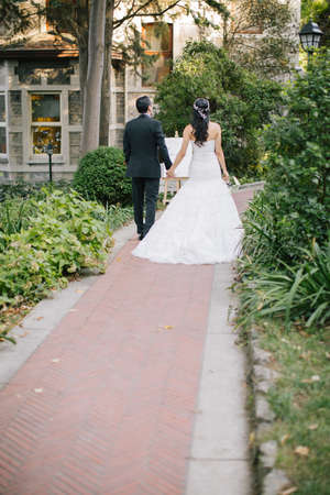 The bride and groom walk side by side and hand in hand.の写真素材