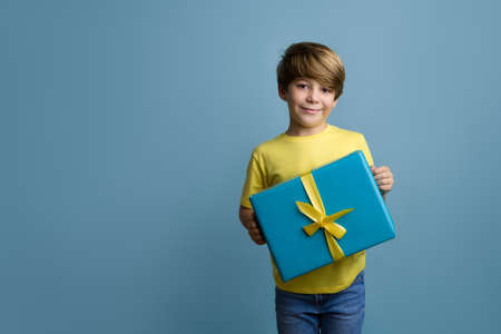 Fun young child enjoying rhythms in listening to music on headphones. Smiling blond boy in yellow...