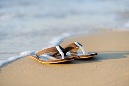 Summer vacation concept. Flip flops on a sandy ocean beachの写真素材