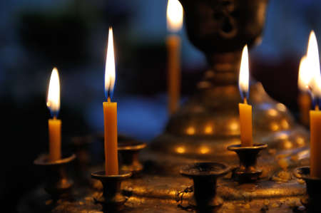 Burning candles in sconces on black blue backgroundの写真素材