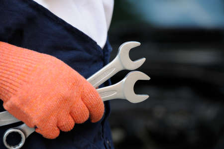 Mechanic holding a wrench at a car garageの写真素材