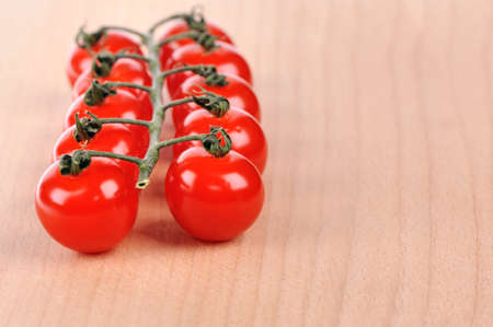 Branch of tomatoes on wooden boardの写真素材