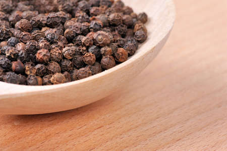 Pepper seeds in wooden spoonの写真素材