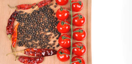 Tomatoes and peppers on wooden boardの写真素材