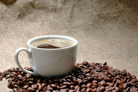 Coffee cup and grain on backgroundの写真素材