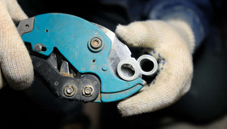 Close up view on pipe cutter with plastical pipeの写真素材