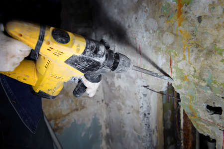 Construction worker making hole a using pneumatic hammerの写真素材