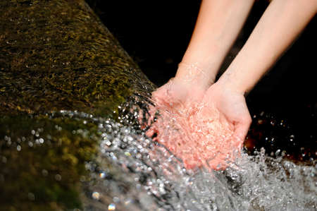 Woman's hands with water splashの写真素材