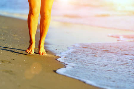 Running legs and shoes of runner jogging on beachの写真素材