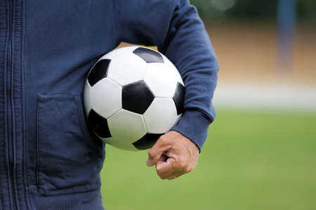 Hand holding soccer ball on stadiumの写真素材