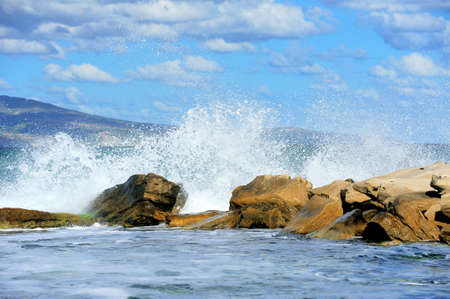 The waves breaking on a stony with day light