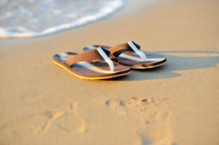Summer vacation concept. Flip flops on a sandy ocean beachの写真素材