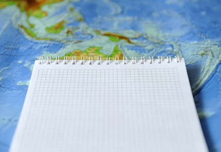 Notebook on a background map of the world. Traveling conceptの写真素材