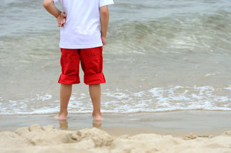 Little boy at tropical beach close up on legsの写真素材