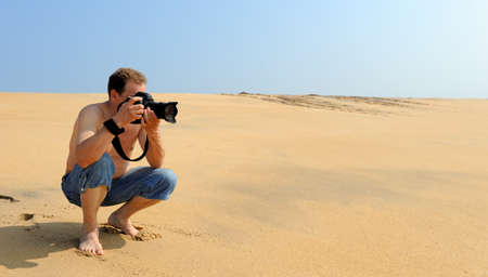 Young photographer taking photos at the beachの写真素材