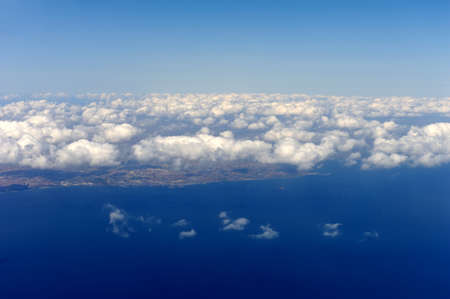 View from airplane window with blue sky and white clouds
