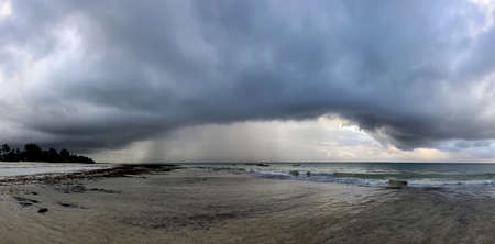 Beautiful tropical beach under gloomy sky. Indian ocean