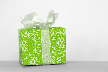 Green gift box with ribbon on white backgroundの写真素材