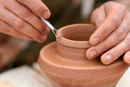 Hands of a potter. Potter making ceramic pot on the pottery wheelの写真素材