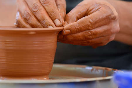Hands of a potter. Potter making ceramic pot on the pottery wheel