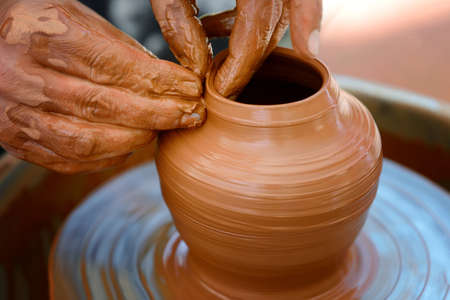 Hands of a potter. Potter making ceramic pot on the pottery wheel