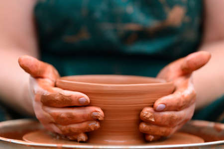Hands of a potter. Potter making ceramic pot on the pottery wheel