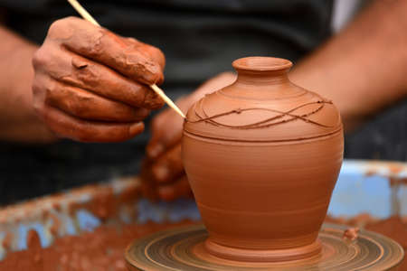Hands of a potter. Potter making ceramic pot on the pottery wheelのeditorial素材