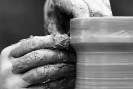 Hands of a potter. Potter making ceramic pot on the pottery wheelの写真素材