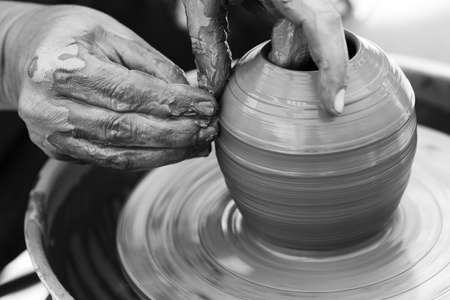 Hands of a potter. Potter making ceramic pot on the pottery wheelの写真素材