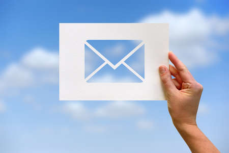 Female hand holding paper blank with email network communication perforated paper letter